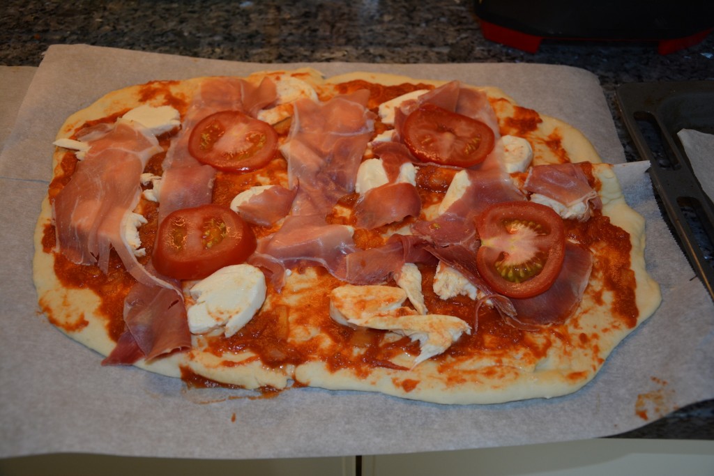 Ogräddad pizza med mozarella och parmaskinka.