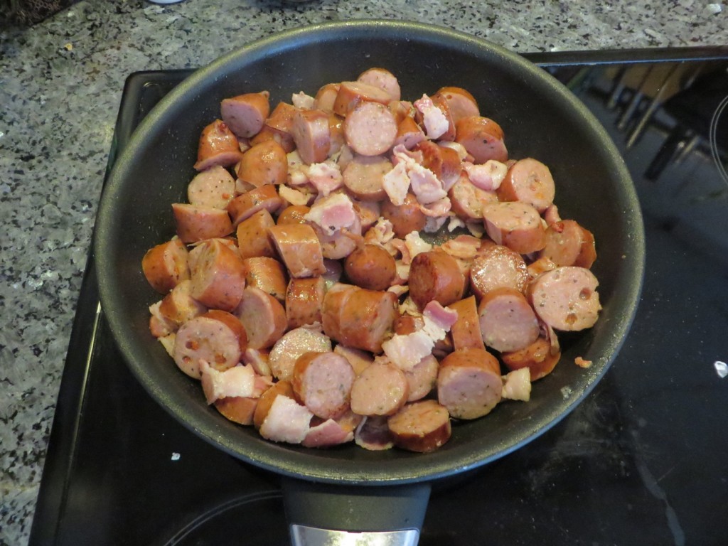 Slantad kycklinggrillkorv och knaperstekt bacon