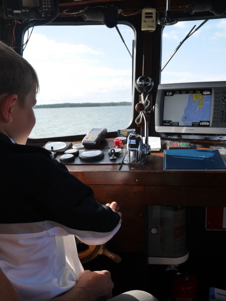 Gustaf får testa att köra båten.