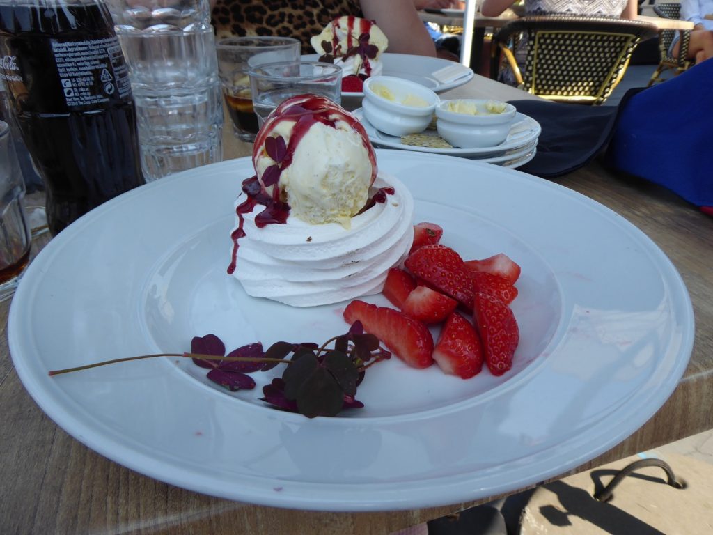 Jordgubbar serverade med vaniljglass, maräng och hallonsås