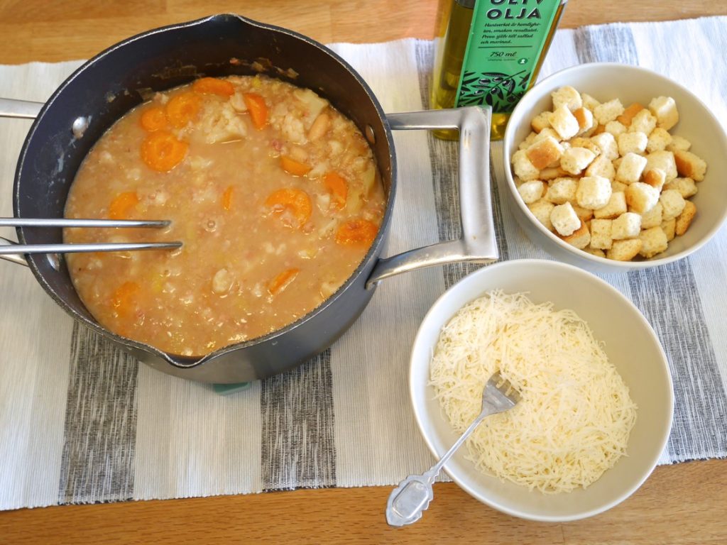 Servera soppan med parmesanost, krutonger och olivolja.