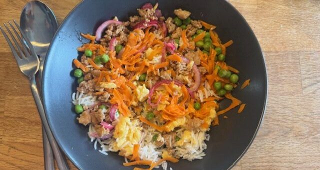 Här har jag toppat med kycklingfärs, ärtor, syrad rödlök, sesamstekta morötter och äggröra.