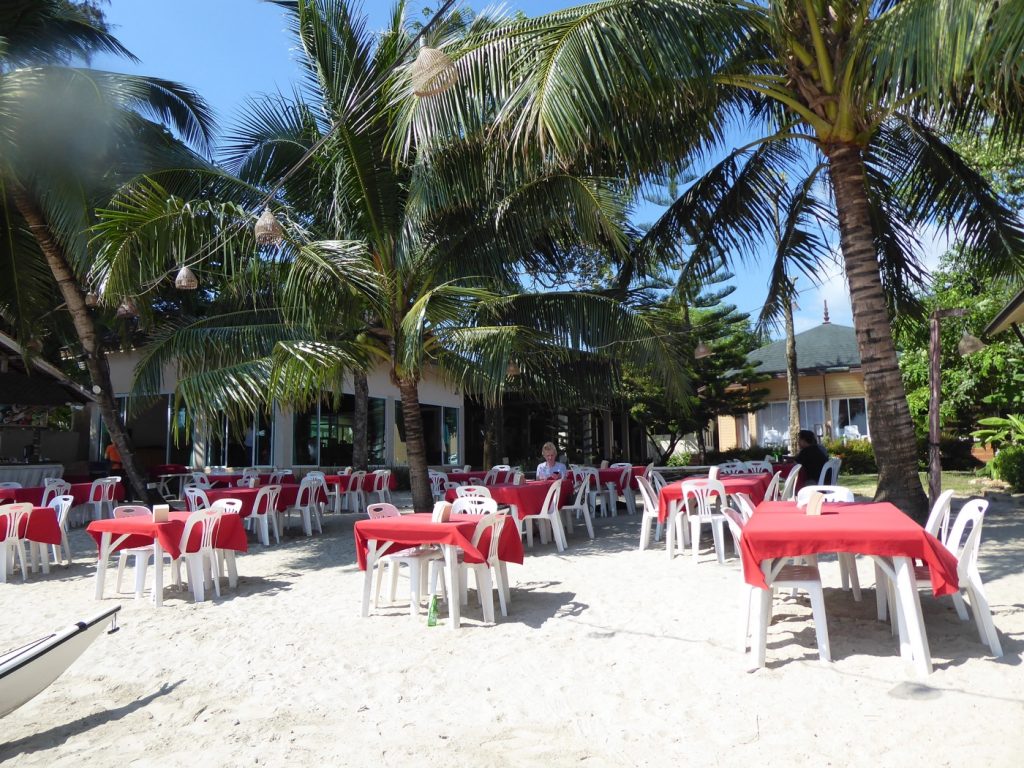 Hotellets restaurang med bord på stranden.